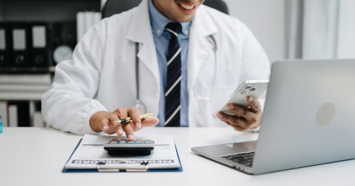 Docter smiling at his phone while running calculations in his calculator.